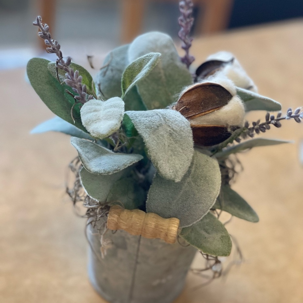 Small metal can with floral arrangement